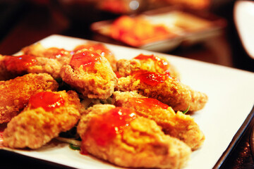 Korean style fried chicken wings Topped with chili sauce, close up, seletive focus