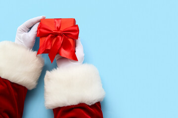 Obraz na płótnie Canvas Santa Claus with red gift box on blue background