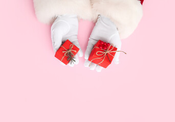 Santa Claus with red gift boxes and rowan on pink background