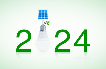 2024 text with solar cell and fresh green tree leaves on soil with led light bulb on white...