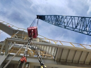 the process of lifting goods using a hook hanging from the crane boom