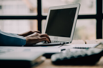 Attractive smiling young asian business woman work at home office, Asian woman working on laptop computer holding tablet.