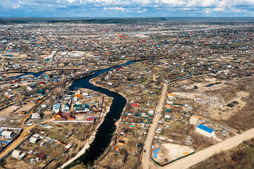 Naklejka premium Aerial view of suburban houses through plane window