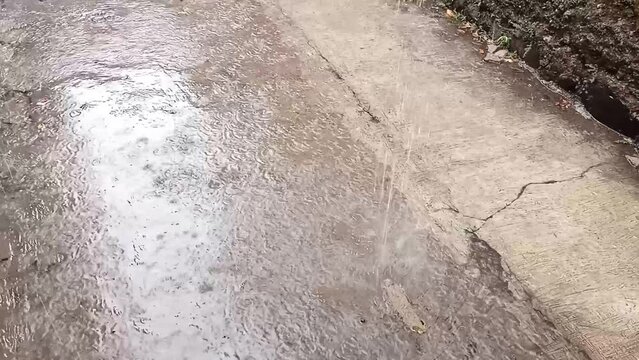 close-up rainwater flows down a drainpipe. Heavy rain in the city.