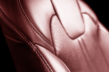 Car red leather interior. Part of red leather car seat details with white stitching. Interior of...