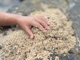 boy playing in the sand rocks in the sea