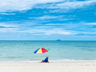 A boy has fun playing with an umbrella in the sand in the sea.
​