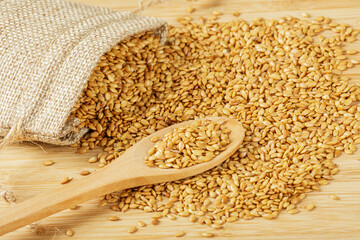 Burlap bag of Roasted Flax Seeds isolated on wooden background