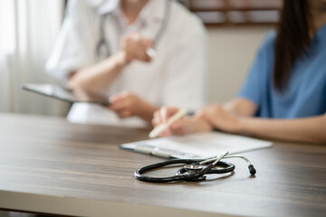 Female doctor sitting at work looking at the history of patients in the clinic or in the hospital
