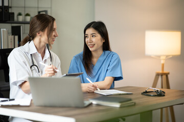 Obraz premium Female doctor sitting at work looking at the history of patients in the clinic or in the hospital
