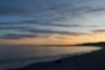 Blurred background of sunset on the French Riviera pebble beach in Nice