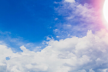 White clouds in bright sunlight. Revival of day. Clouds in glare of sun.