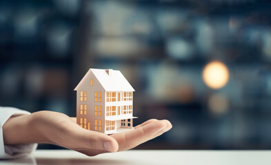 Hands holding paper house miniature, insurance and real estate concept