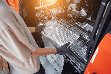 Tunning service worker install soundproofing material inside car interior