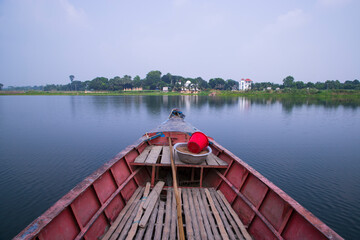 On long tail traditional transportation boat with horizon lines in Bangladesh