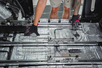 Tunning service worker install soundproofing material inside car interior
