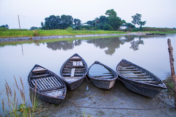 Obraz premium landscape view of Traditional wooden fishing boats on the shore of the Padma River in Bangladesh