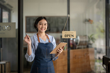 Startup business owner standing in an apron prepare to receive orders. SME entrepreneur invite and present with pride of her coffee shop business.