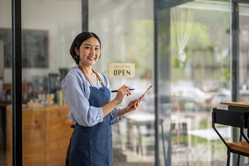 Startup business owner standing in an apron prepare to receive orders. SME entrepreneur invite and present with pride of her coffee shop business.