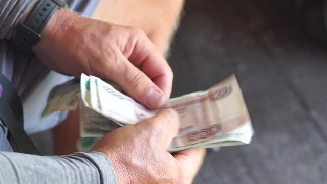Man hands counting money, close-up. Financial literacy concept, counting paper banknotes, Russian rubles. Unrecognizable person, male hands, outdoor scene