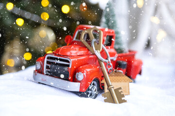Red retro car with a Christmas tree decorates with the house key in the pickup truck for Christmas....
