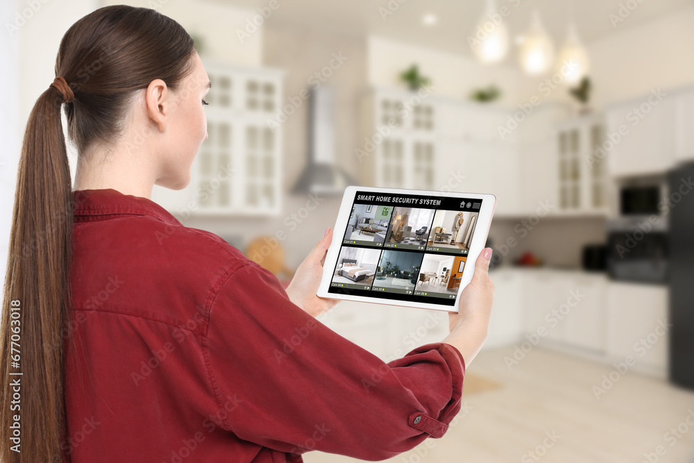 Aufkleber woman using smart home security system on tablet computer indoors. device showing different rooms th