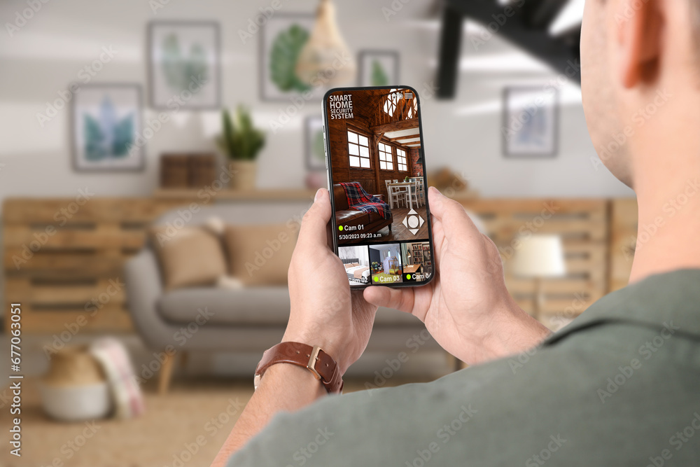 Aufkleber man using smart home security system on mobile phone indoors, closeup. device showing different room