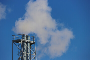 A metal pipe with white smoke coming from it.