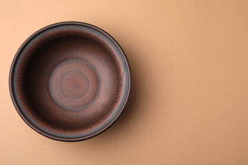 Ceramic bowl on beige background, top view. Space for text