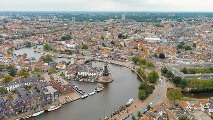 Fotobehang Haarlem, Netherlands. Windmill De Adriaan (1779). Windmill from the 18th century. Panoramic view of Haarlem city center. Cloudy weather during the day. Summer, Aerial View © nikitamaykov
