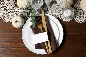 Beautiful autumn table setting, pumpkins, eucalyptus and blank card, flat lay
