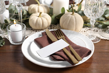 Beautiful autumn table setting. Plates, cutlery, blank card and floral decor