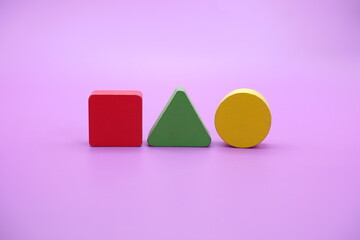 Set of colorful wooden shape toy (Square, triangle, round) on Purple background