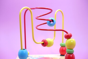 Children's educational toy isolated on purple background. toddler toys. toys with iron wire and beads.