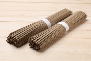 Uncooked buckwheat noodles (soba) on light wooden table