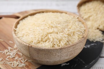 Raw rice in bowl on table, closeup