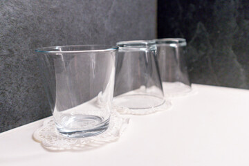 .Glass glasses are placed next to each other on the edge of a white sink