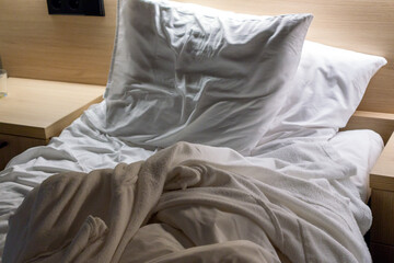 Fototapeta na wymiar .An unmade bed with a wrinkled blanket and two pillows