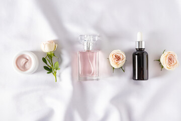 A set of cosmetics and perfumes for care and beauty at home. bottles and fresh flowers. Flat...