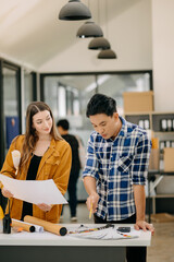 Fototapeta premium Two colleagues discussing data working and tablet, laptop with architectural project at construction site at desk .