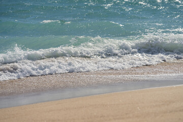 Waves rolling on a sandy beach on a sunny day