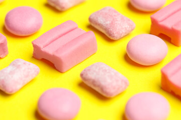 Pink bubble gums on yellow background, closeup