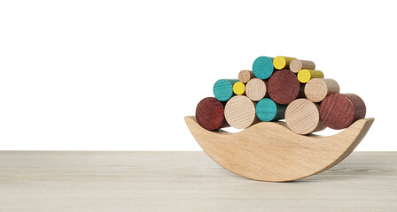 Wooden balance toy on table against white background, space for text. Children's development