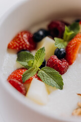 Sweet milk semolina porridge with strawberries on beautiful plate. Delicious breakfast for children