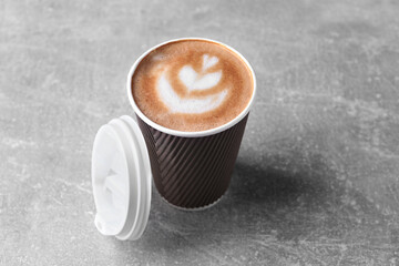 Coffee to go. Paper cup with tasty drink on grey table - obrazy, fototapety, plakaty