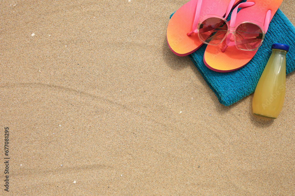 Poster Stylish sunglasses, flip flops. towel and bottle of refreshing drink on sand, above view. Space for text