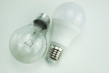 detail of tungsten bulb next to round led bulb