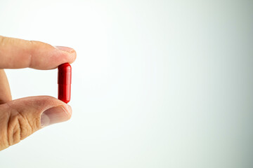 A detail of a calming pill held between two fingers