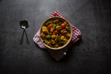 Indian main course dish mixed veg curry prepared with carrots, cauliflower, beans, capsicum and...