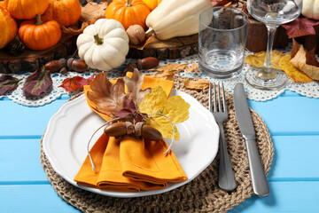 Happy Thanksgiving day. Beautiful table setting with autumn decor on light blue wooden background